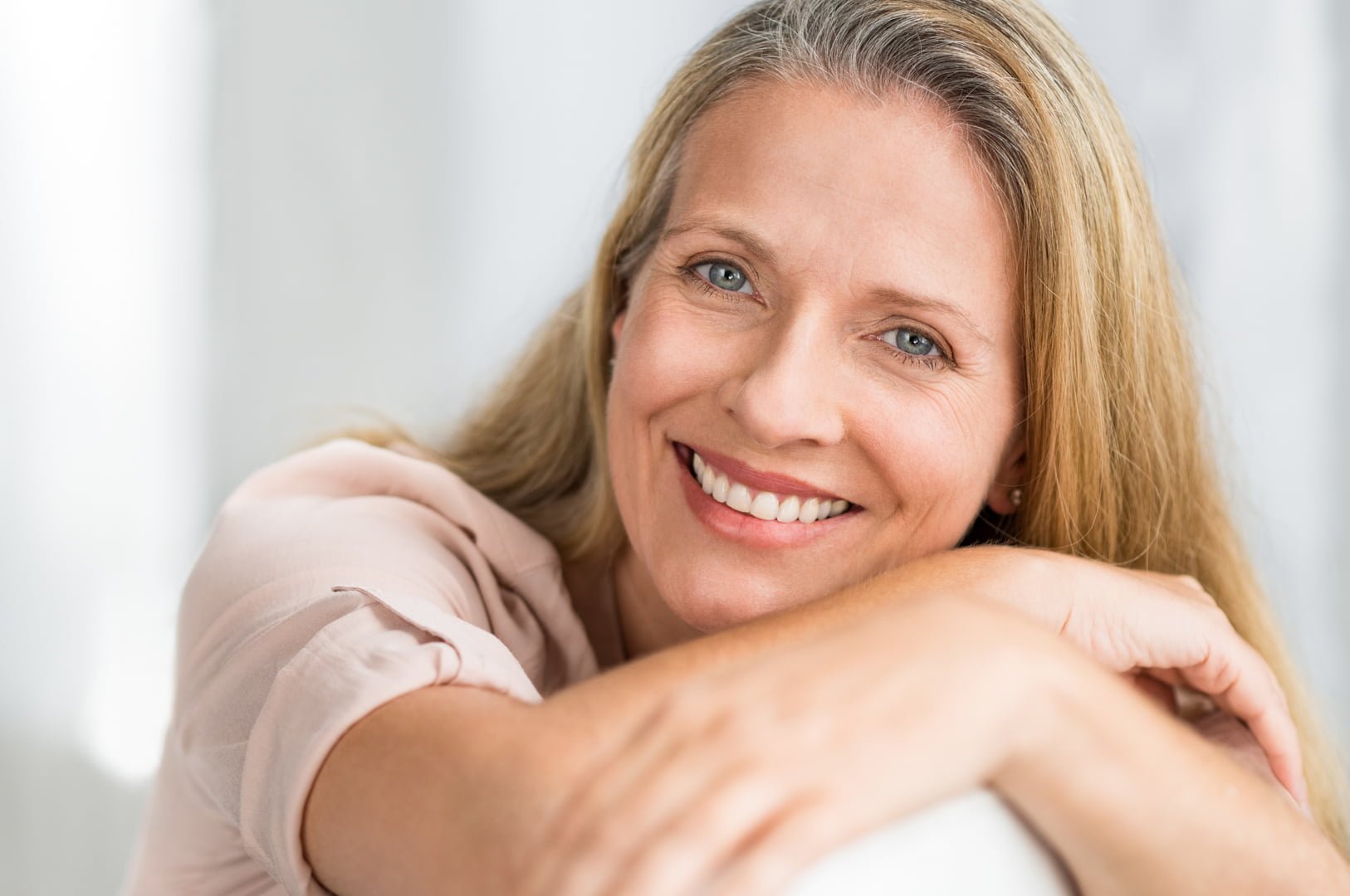 Portrait of happy senior woman relaxing on sofa.