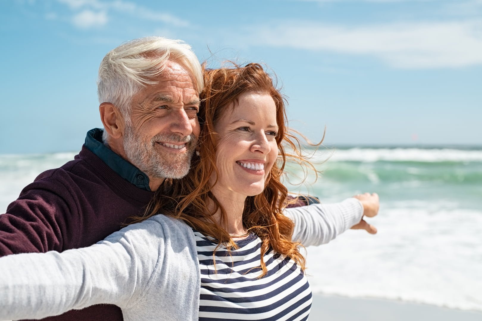 Romantic senior couple with outstretched arms enjoying vacation